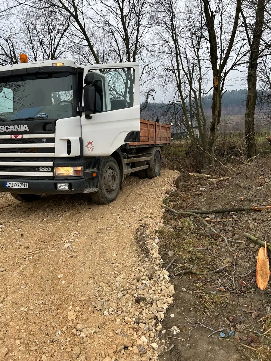 Wywrotka Scania 220 4×2 na świeżo wykonanej drodze z kruszywa w lesie